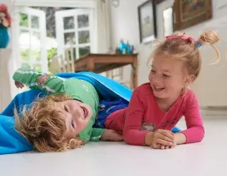 Videohometraining - broer en zus op de grond aan het spelen