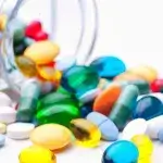 medicijnen - potje met verschillende kleuren medicijnen valt om op tafel