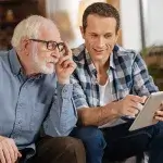 Domotica - oudere en jongere man kijken op tablet