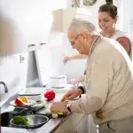 Respijtzorg of vervangende mantelzorg: oudere man in keuken met vrijwilliger