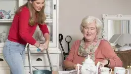 service aan huis - jonge dame sopt de kastjes bij oudere dame thuis