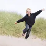 Jongetje rent blij over het strand