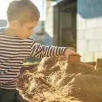 Jongen maakt een zandkasteel