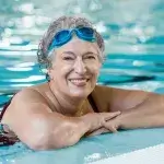 Oudere vrouw aan de rand van het zwembad