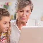 Online hoortest - Oma en kleindochter met laptop in keuken