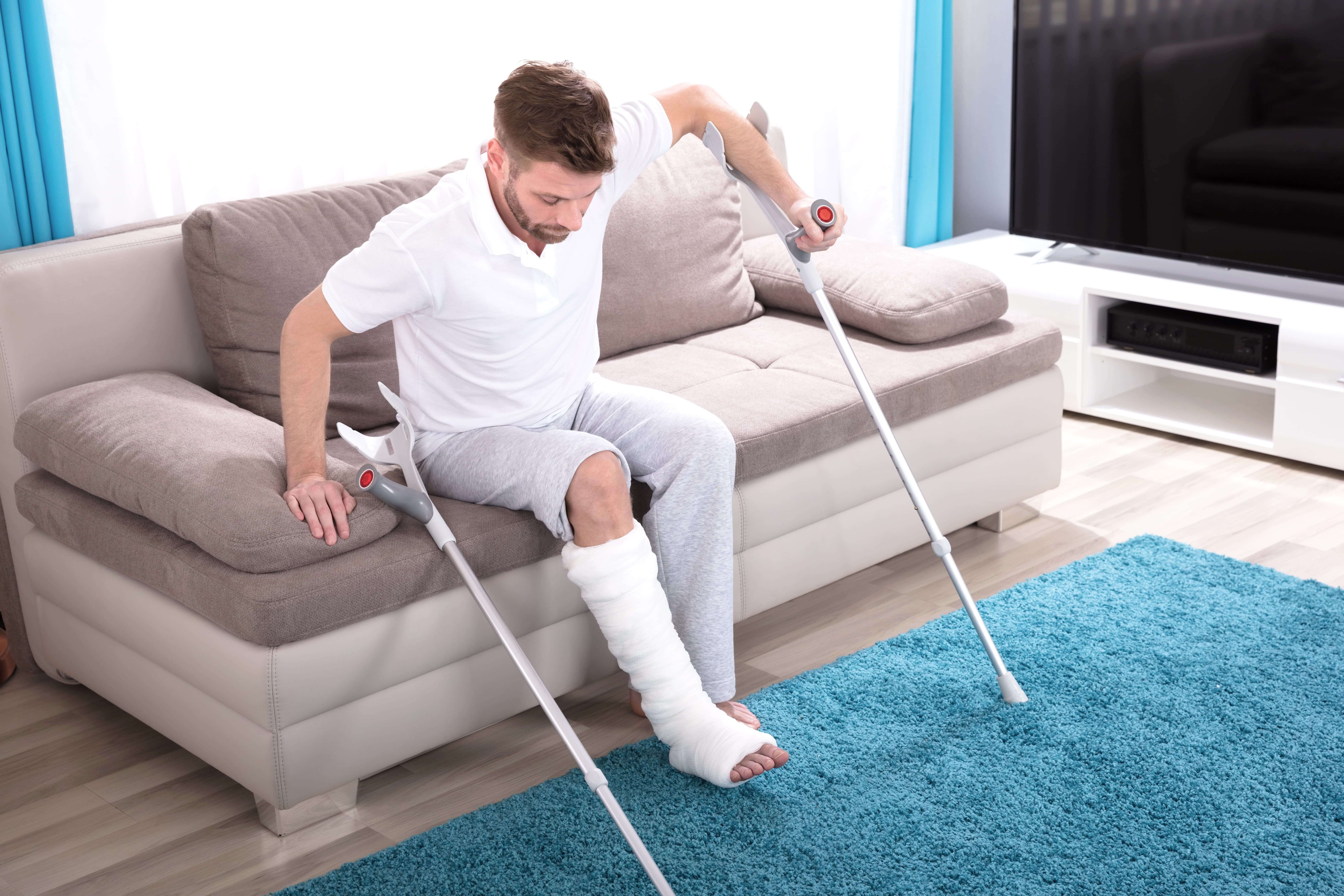 Man met gebroken been gebruikt krukken - loophulpmiddelen