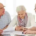 Oudere man en vrouw overleggen met zorgprofessional