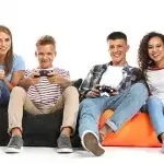 Kind gameverslaafd - 4 teenagers met gameconsoles op de bank