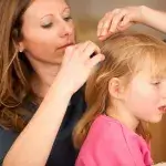 Een moeder controleert het haar van haar dochter