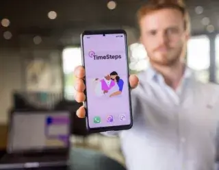 Tim van Santen houdt mobiel vast met TimeSteps App