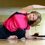 Yoga - Oudere dame doet oefeningen op yogamat