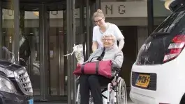 hulp bij cirsis - oude dame in rolstoel buiten met verpleegkundige 
