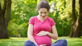 zwanger - zwangere vrouw zittend in het gras