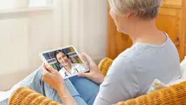 e-health - middelbare vrouw praat thuis via tablet met arts
