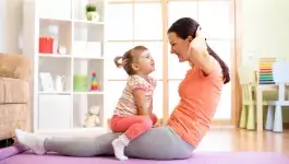 Thuis fit blijven - moeder en dochter doen oefeningen in huiskamer