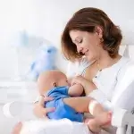 baby verzorgen - moeder zit op stoel en geeft baby borstvoeding