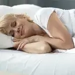 Beter slapen goede nachtrust - Vrouw ligt in bed te slapen
