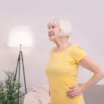 Blijf actief thuis - oudere vrouw doet oefeningen in huiskamer