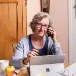 Digitale hulplijnen - vrouw met laptop aan de telefoon