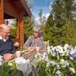 Gezond eten bij dementie - Een echtpaar eet in de zon op het terras bij huis