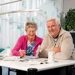 Man en vrouw van 70 aan tafel thuis