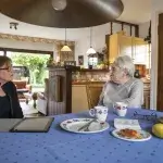 Laatste wens - Oudere vrouw spreekt andere vrouw aan de keukentafel