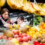 Vrouw koopt fruit en groente op markt
