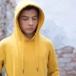 Zelfhulp depri - Jongen met gele hoodie kijkt somber