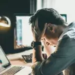 Zelfhulp Werkstress - Man zit gestresst achter bureau