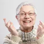 Diabetes gebitsproblemen - oudere vrouw lacht met haar handen omhoog