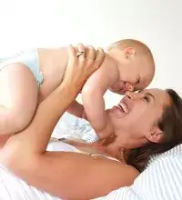 Borstvoeding- en kolfspreekuur - Moeder houdt haar baby boven zich