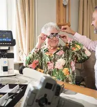 Opticien aan huis bepaalt de brilsterkte bij een oudere mevrouw