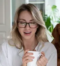 Vrouw drinkt koffie achter laptop