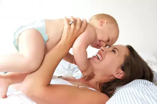 Borstvoeding- en kolfspreekuur - Moeder houdt haar baby boven zich
