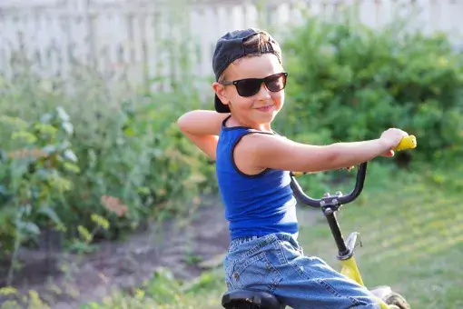 Veilig op pad - jongen met petje en zonnebril op fiets